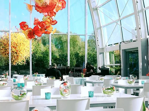 White event tables beneath the colorful glass installation at Chihuly Garden and Glass